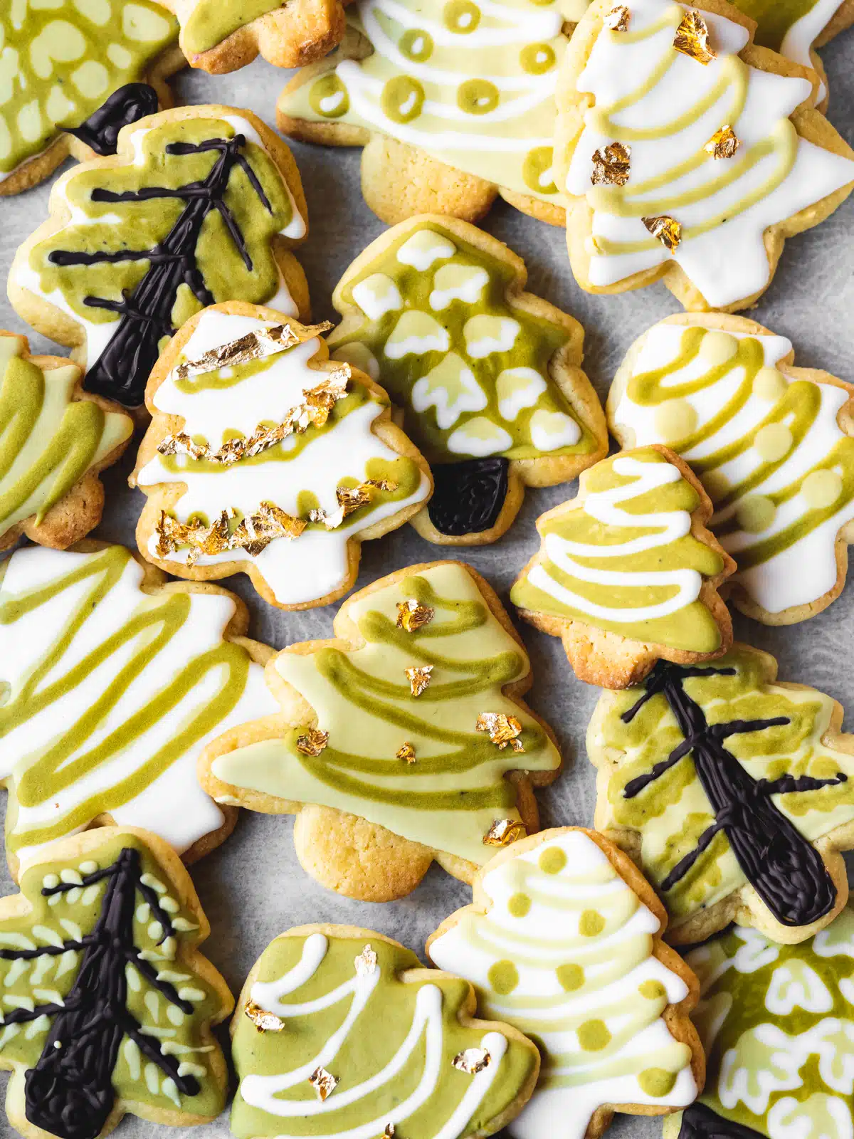 A plate of holiday cookies decorated with green and white icing.
