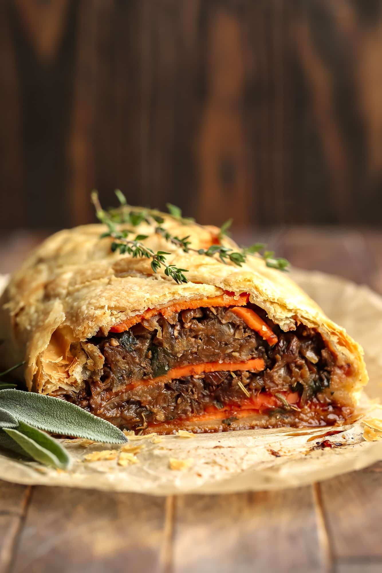 A vegan meat pie with carrots and sprigs of sage.