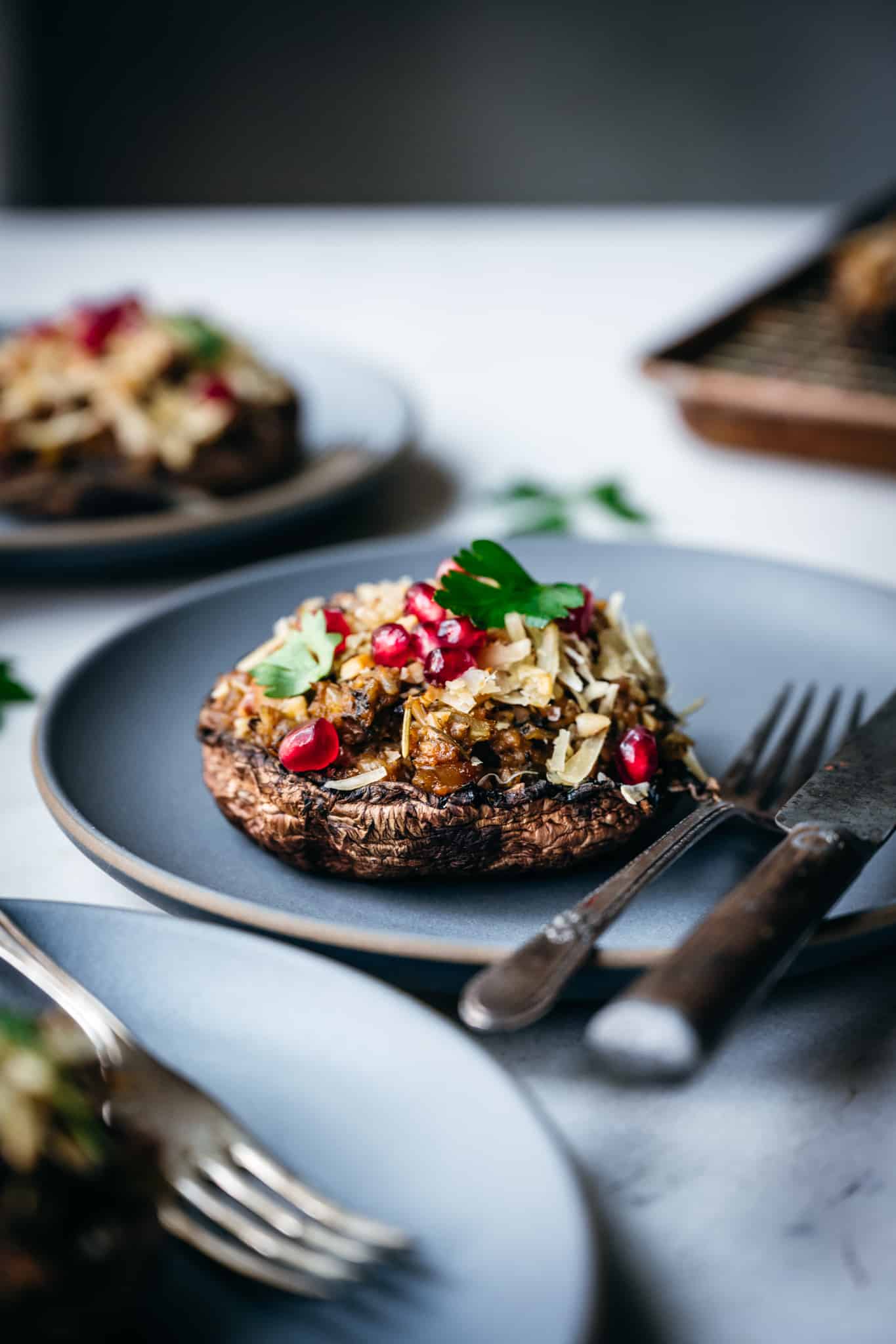 Vegan Stuffed mushrooms with pomegranate on a plate, perfect for holiday recipes.