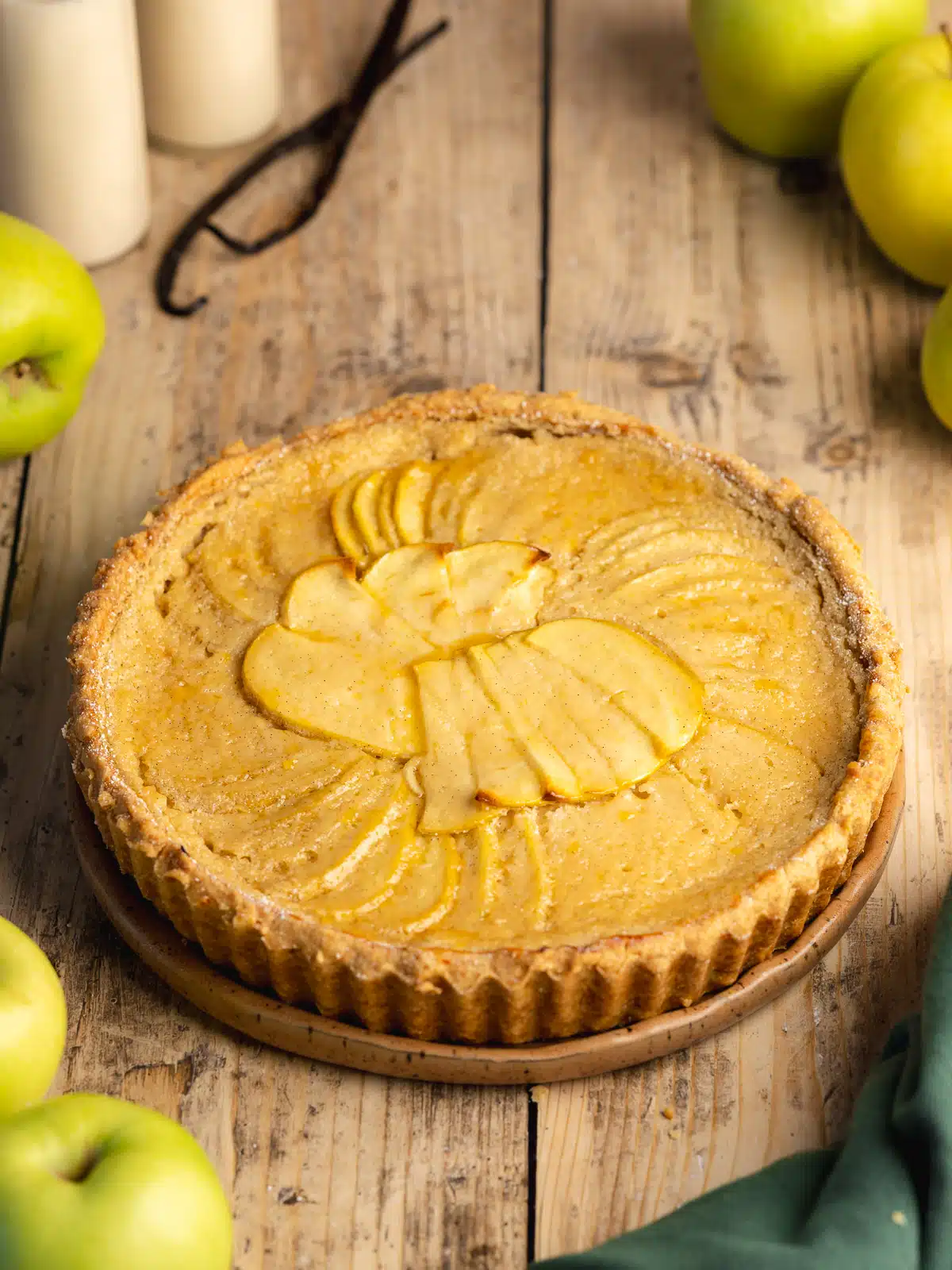 A vegan tart with apples on top of a wooden table.