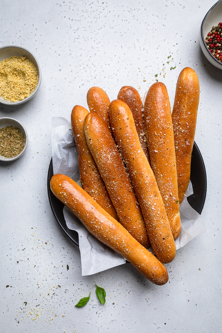 Vegan bread sticks on a plate with holiday spices and seasonings.