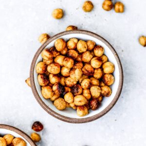 Bowl of cheesy roasted chickpeas on a gray background.