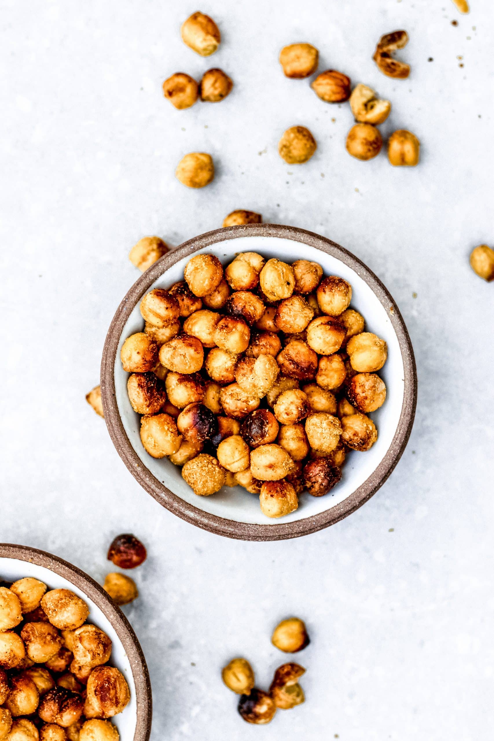 Bowl of cheesy roasted chickpeas on a gray background.