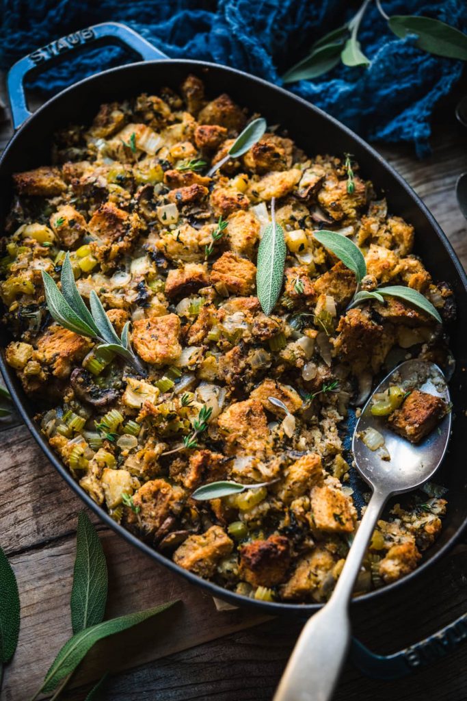 Cast iron pan of stuffing with fresh sage and a blue napkin.