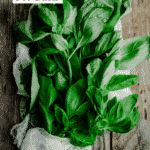 Fresh basil in a cloth bag on a wooden table.