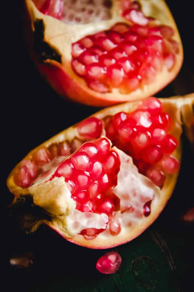 Pomegranate that's cut open showing its pink arils.