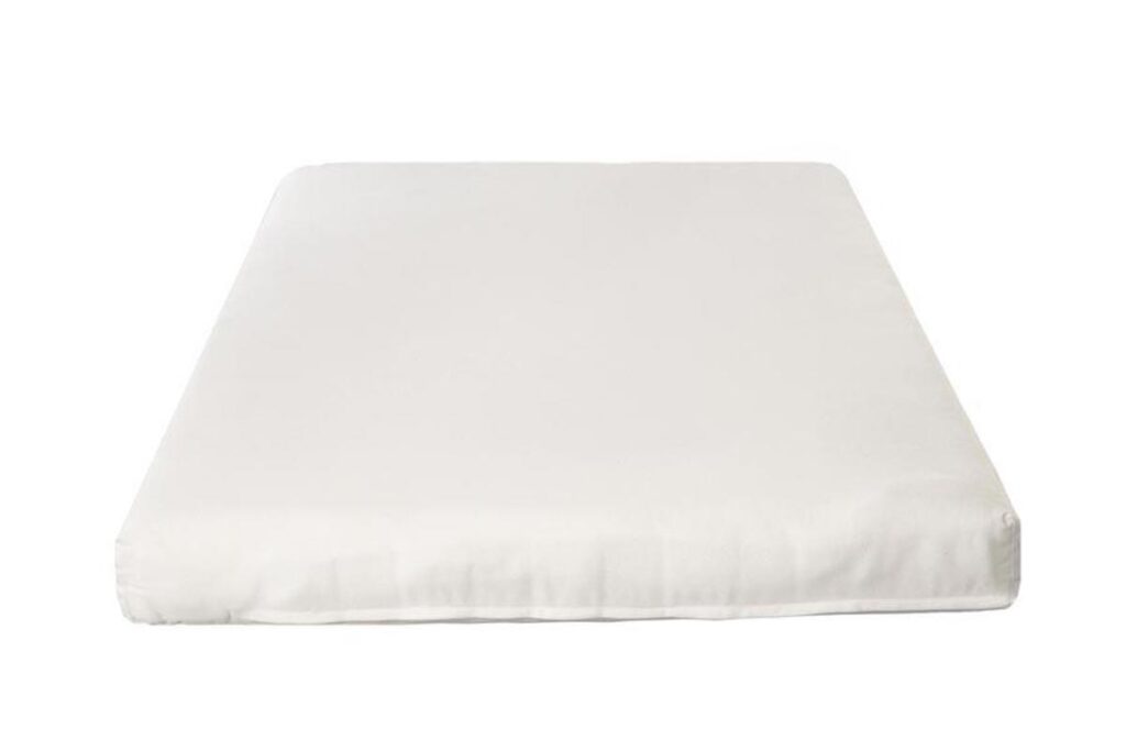 Cream colored latex crib mattress.