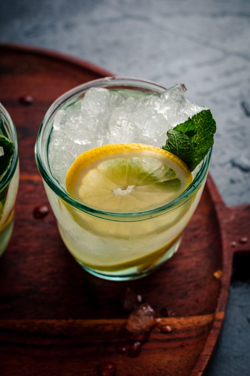 Glass of ginger lemonade with fresh lemon slice and mint.