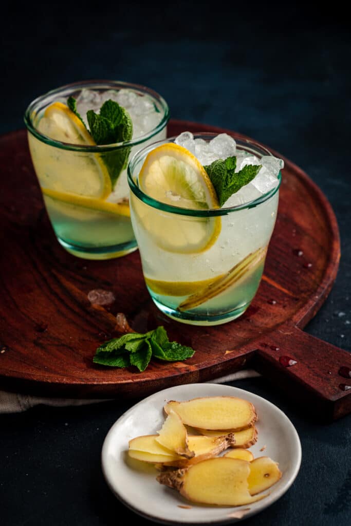 Two glasses of lemonade on a wooden tray.