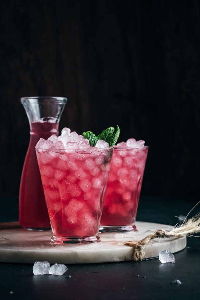 Two cups of cranberry lemonade with fresh mint in the glass.