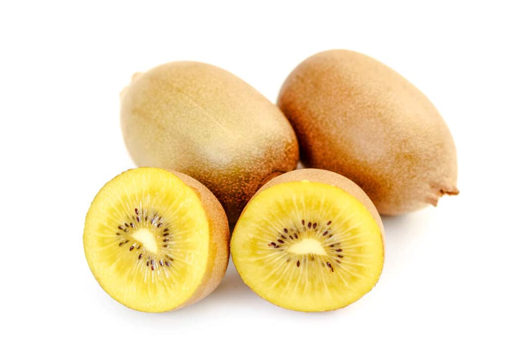 Three light gold kiwis with one cut in half.