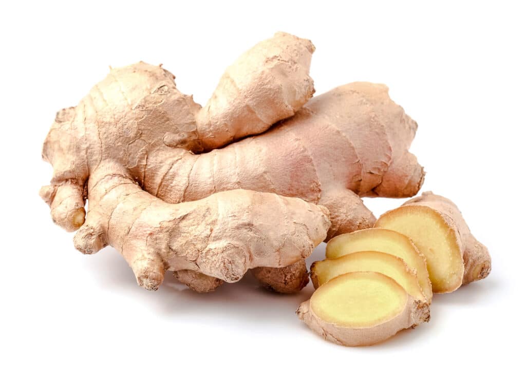 Fresh ginger root with a few slices cut off.