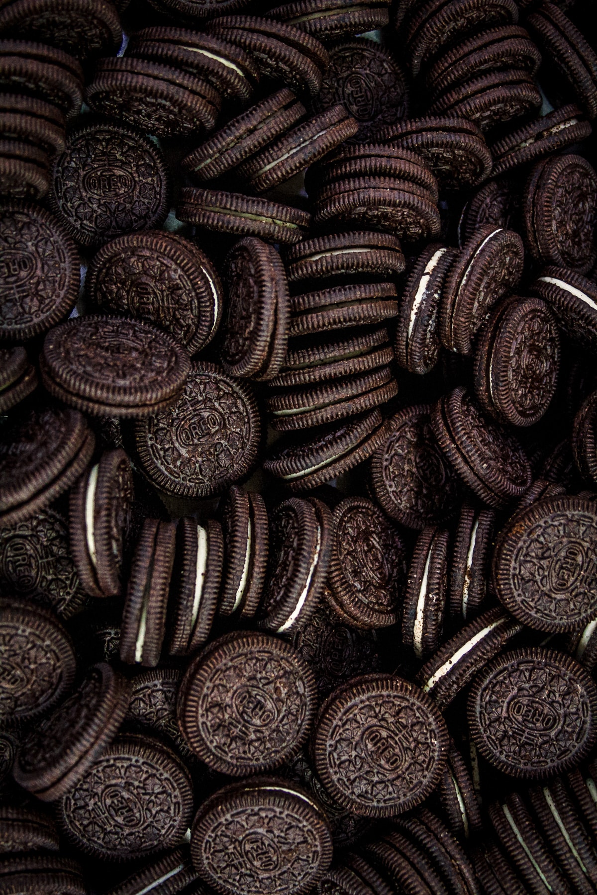 Large pile of dozens of Oreos cookies covering the surface.