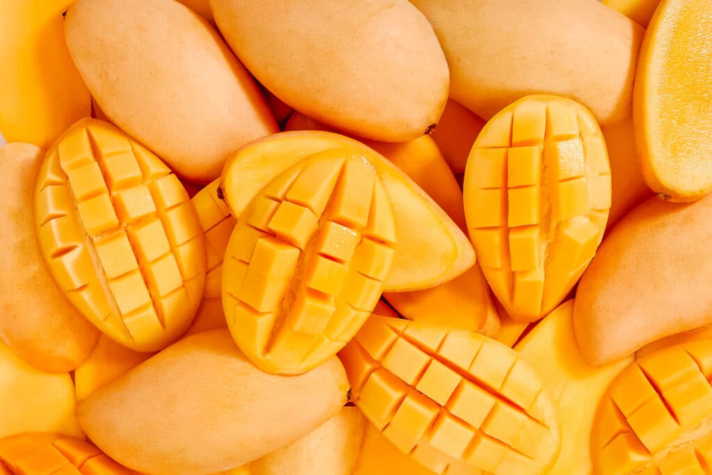 Pile of Ataulfo Mangoes with a few cut in half and sliced.