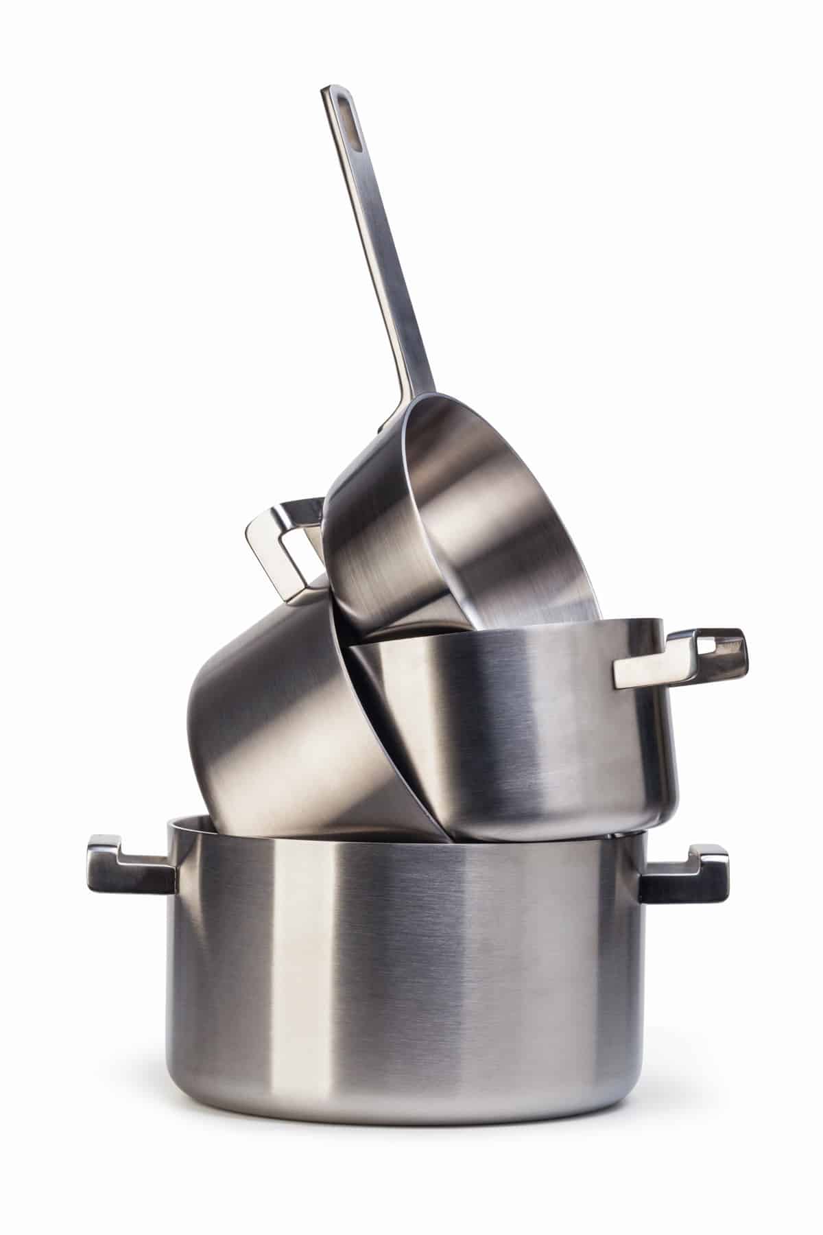 Four stainless steel pots stacked on top of each other.