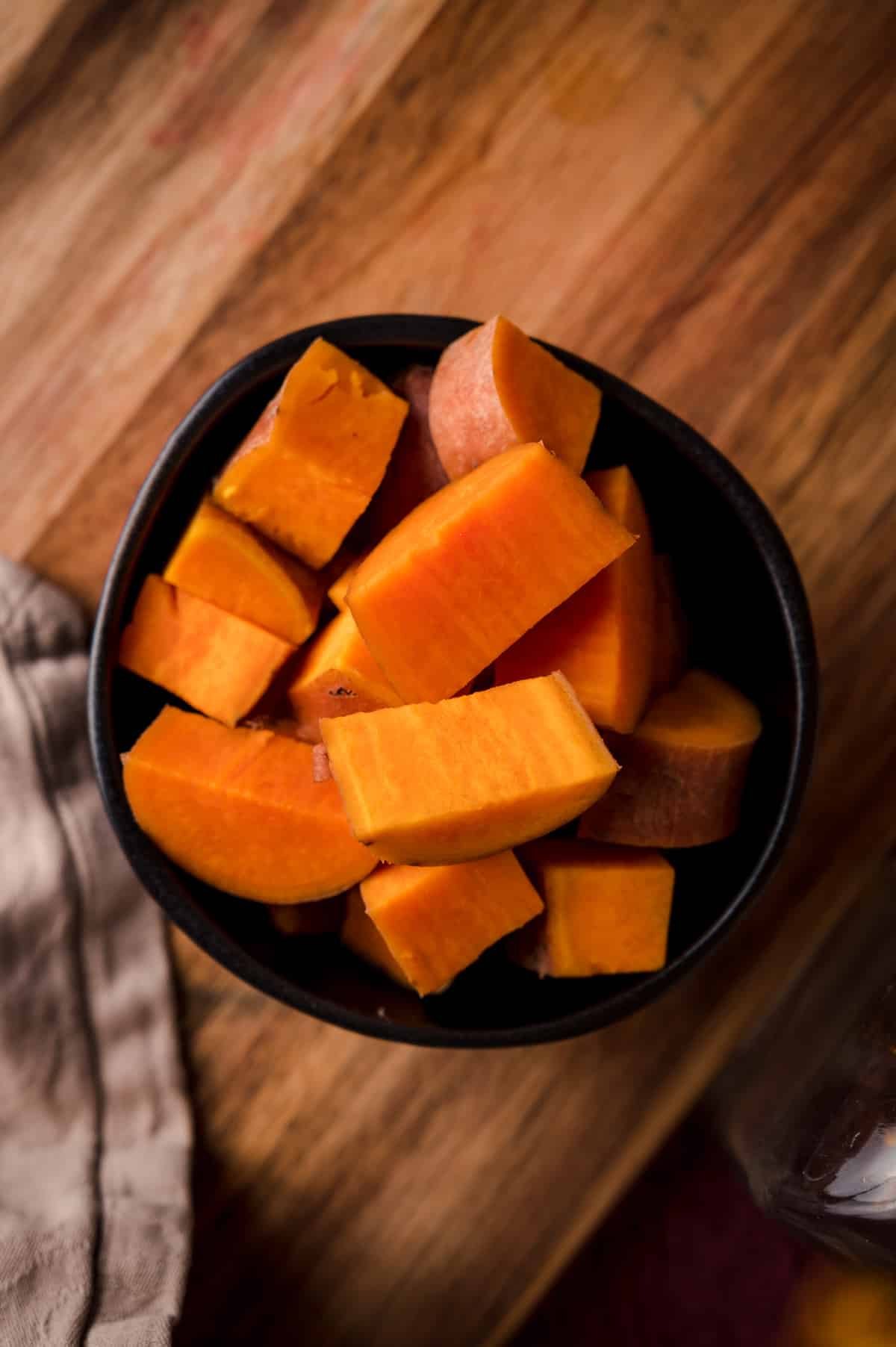 Close up view of a bowl of cooked sweet potato.
