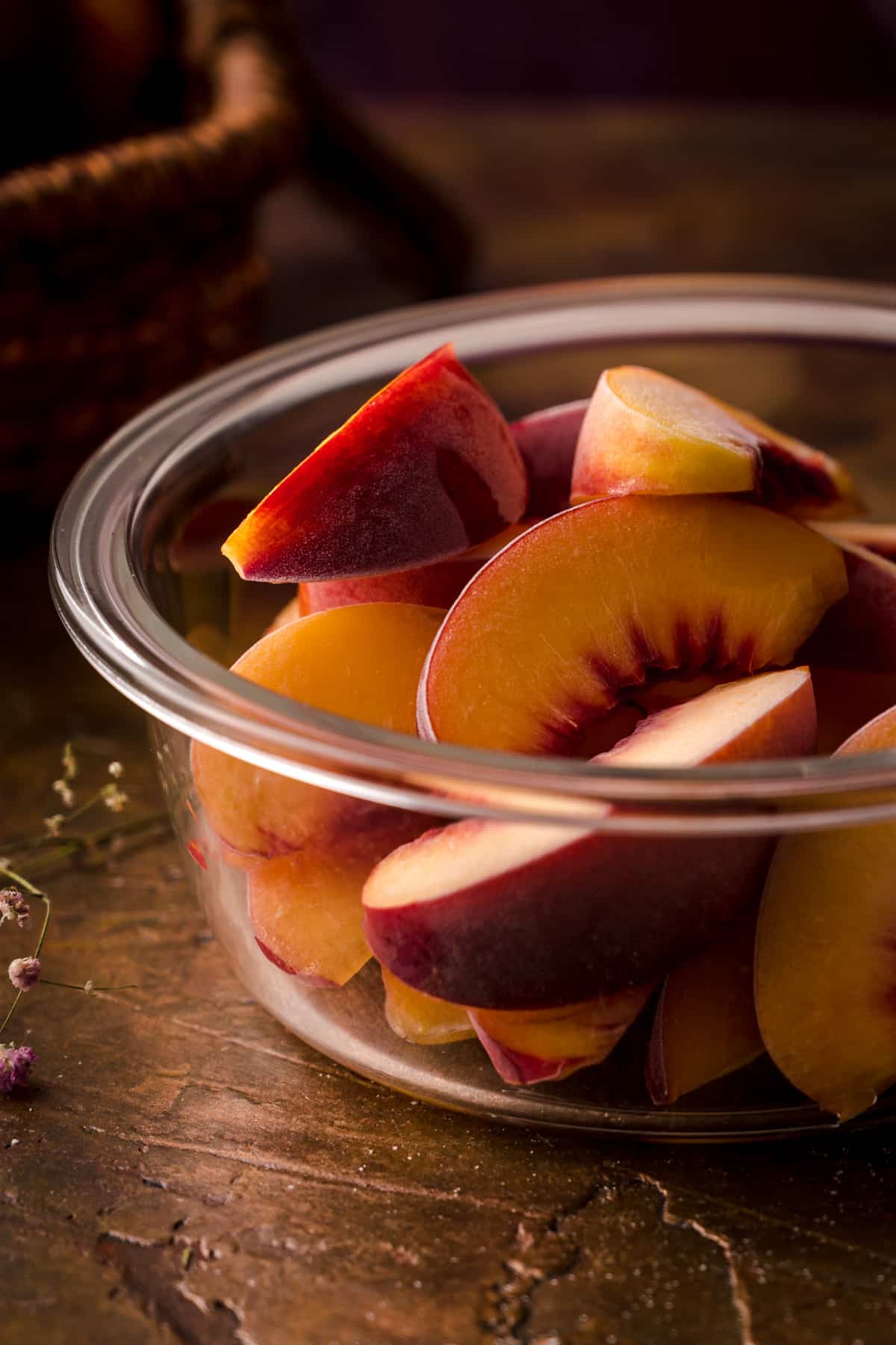 Frozen Peaches transferred to a glass freezer safe container.