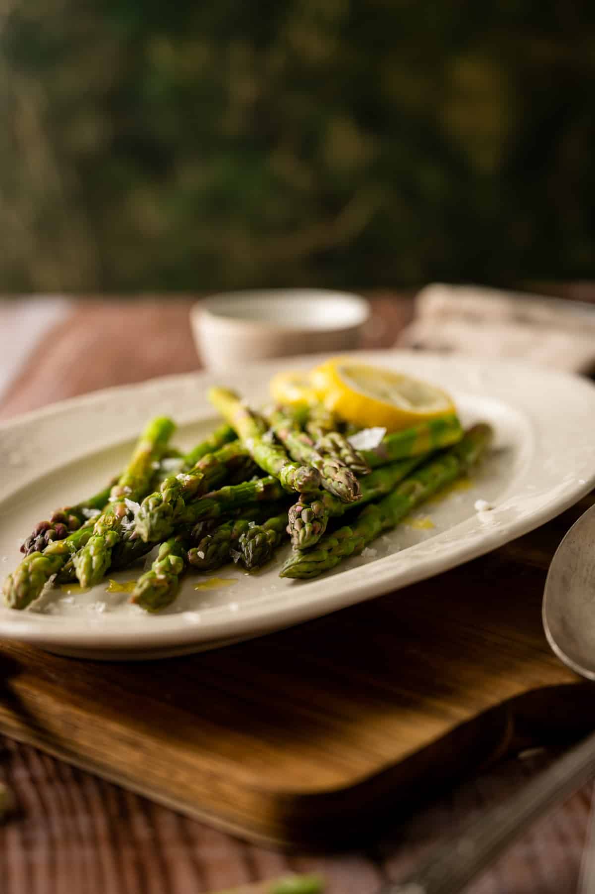 Angle view of cooked asparagus on a oval plate.