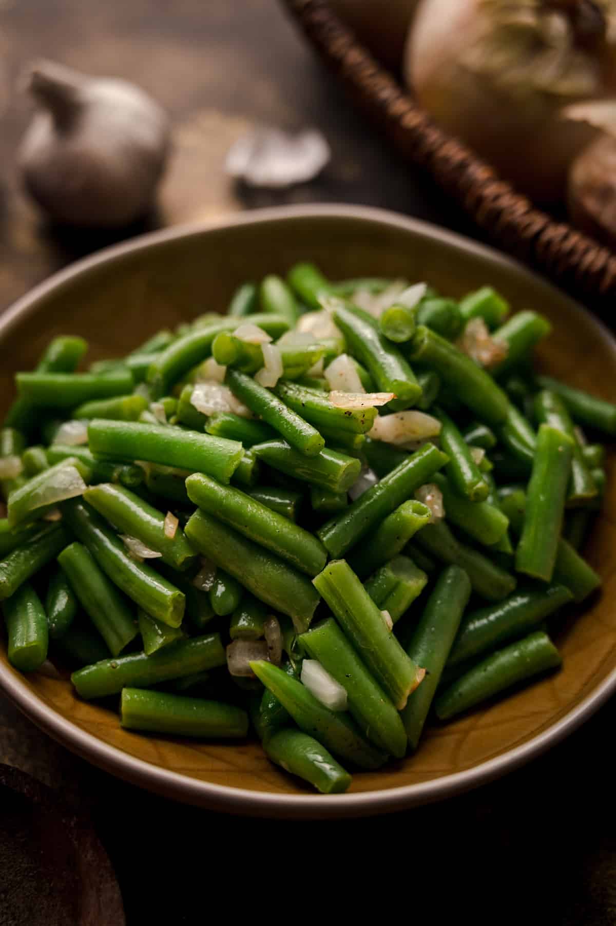 Cooked green beans from a can with sauteed onion garlic and spices.