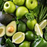 Close up of an array of green fruits on a table.