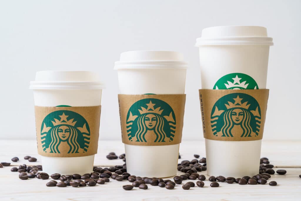 Tall, grande, and venti Starbucks hot cups with green logos.