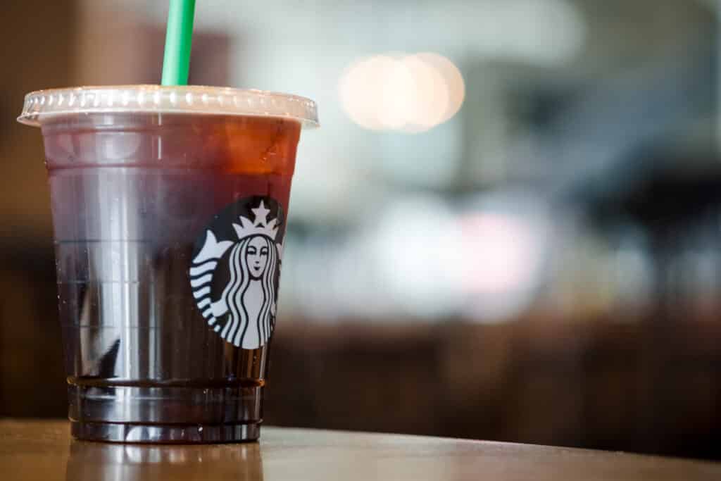 Iced cold brew coffee in a Starbucks disposable cup.