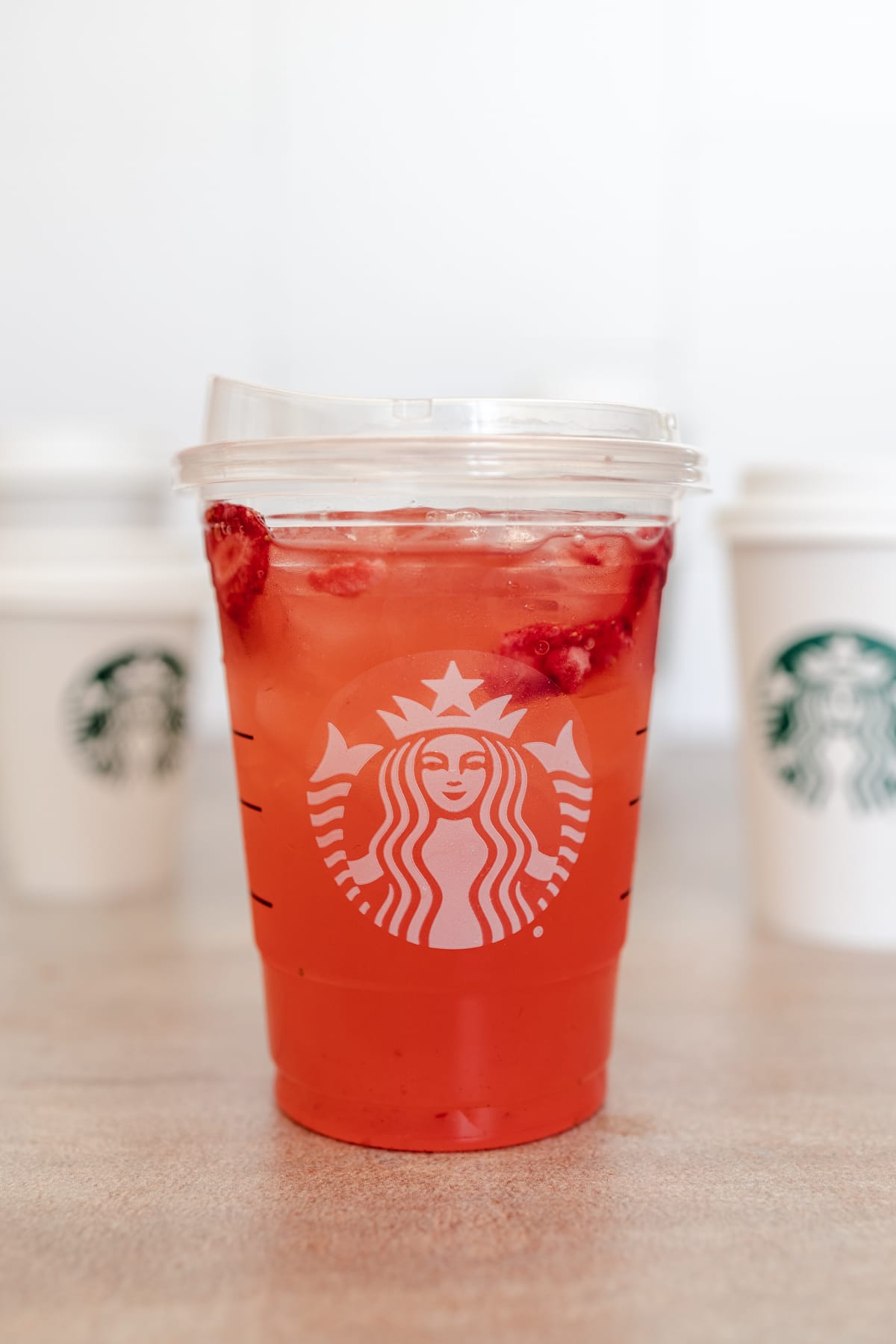 Strawberry refresher in a disposable plastic cup.