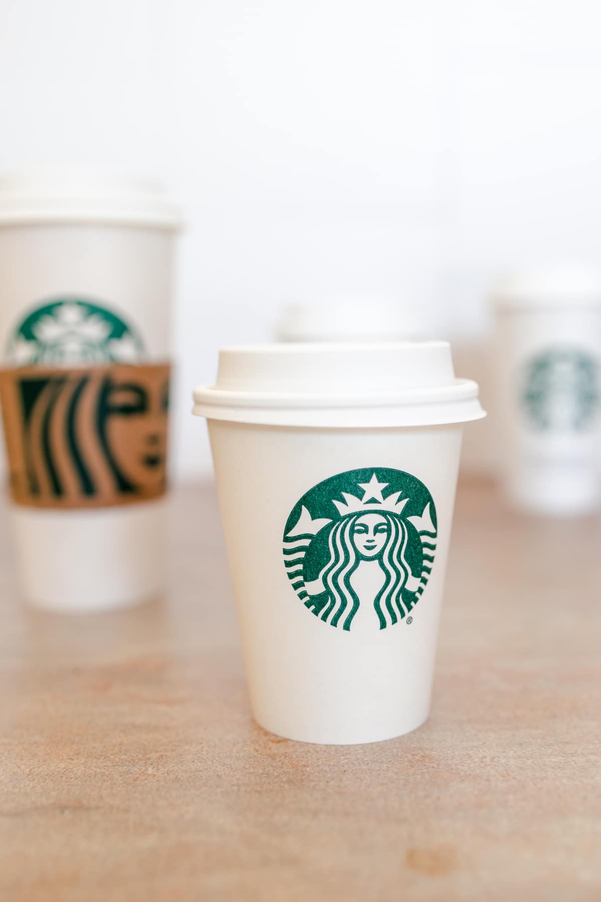 White disposable Starbucks hot cups of different sized.