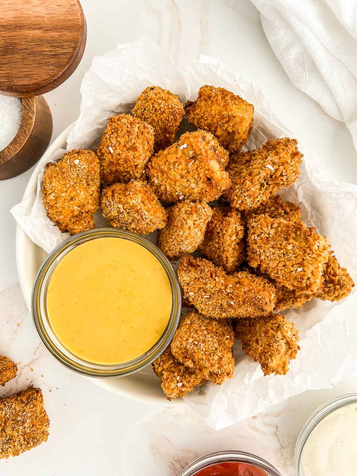 Vegan tofu nuggets in a bowl with dipping sauce.