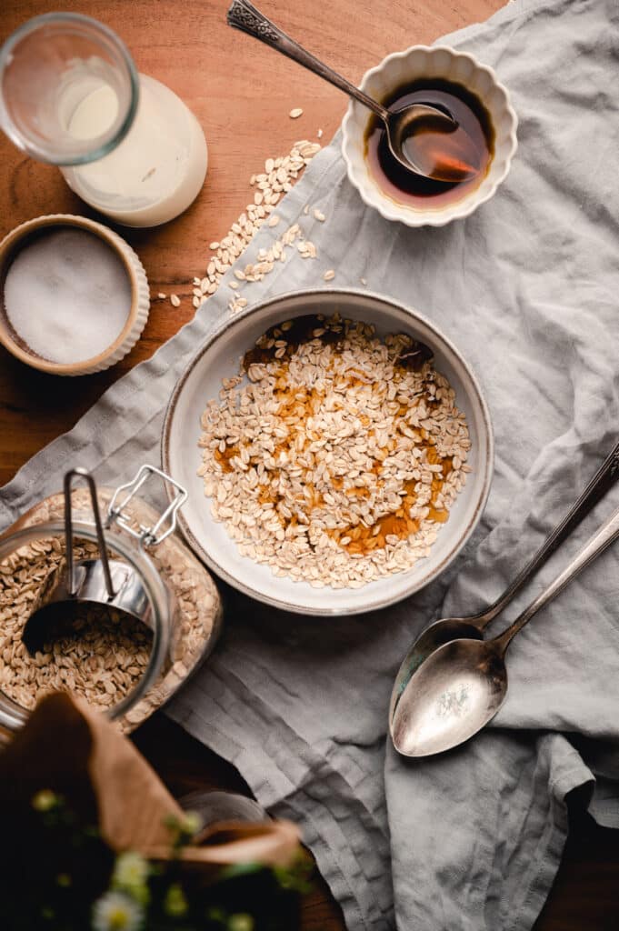 Maple syrup drizzled into a bowl of oats for creamy oatmeal recipe.