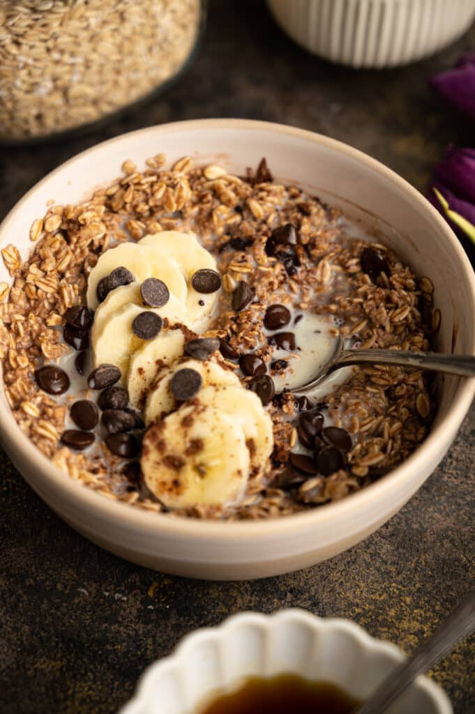 Bowl of healthy chocolate oatmeal with a silver spoon in it.