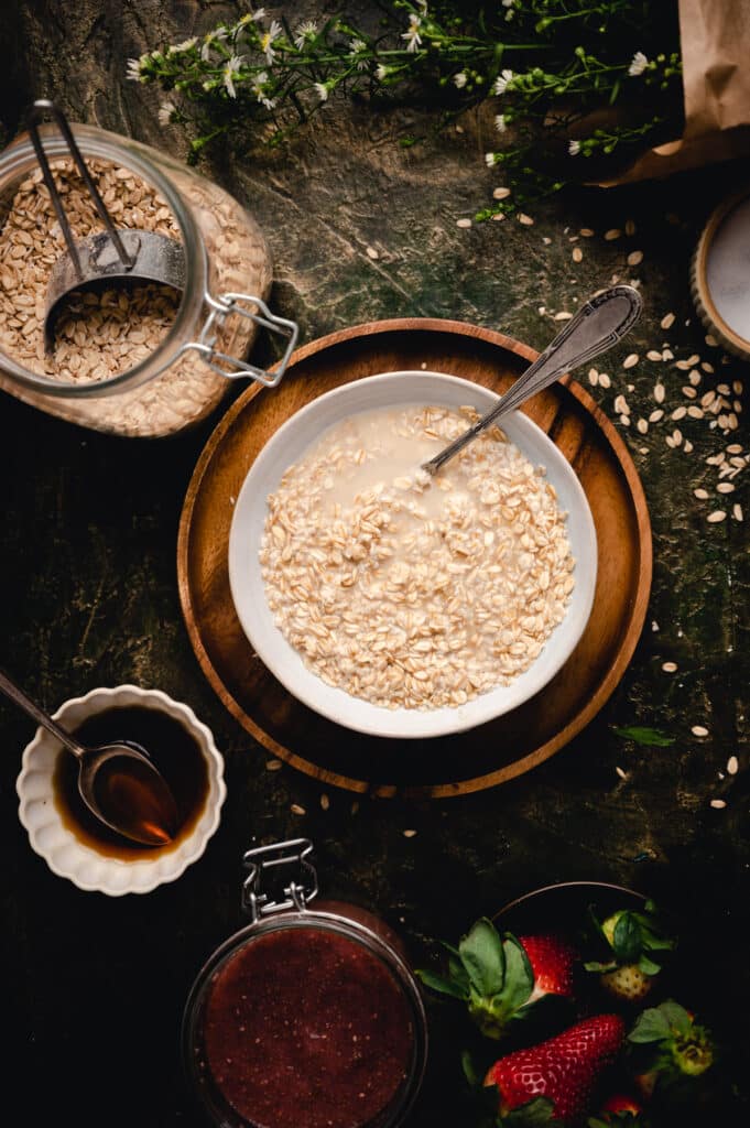 Old-fashioned oats in a bowl with maple syrup and hot water added.