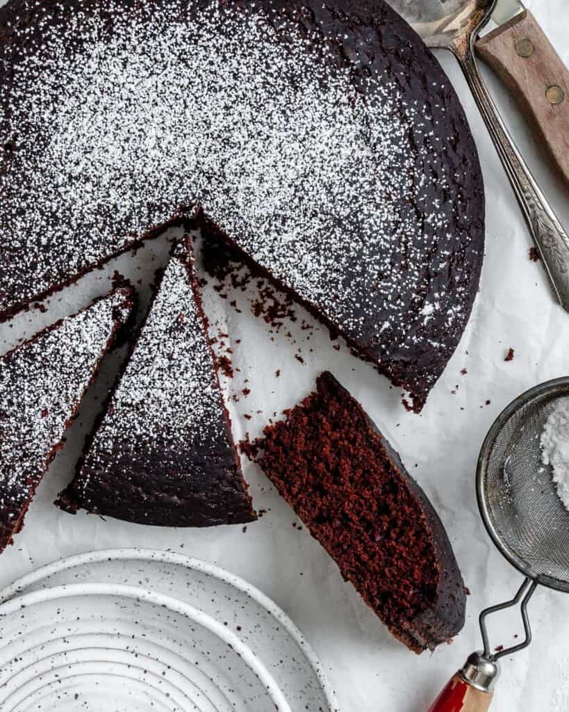 A single layer chocolate depression cake with powdered sugar dusted on top.