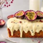 Passionfruit cake dripping in vegan frosting with fresh passionfruit on top.