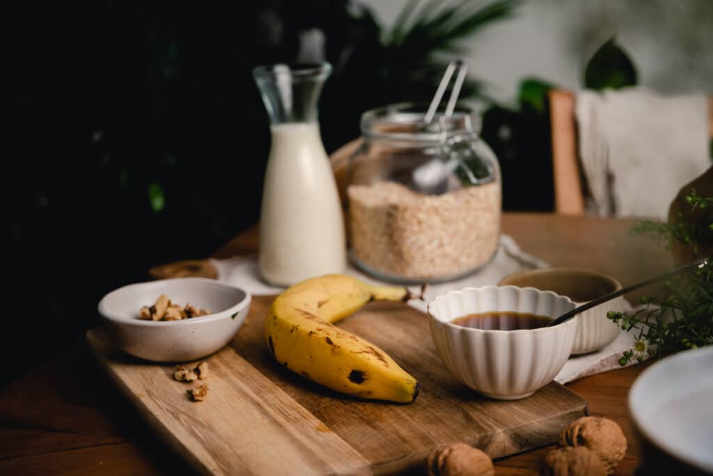 Wooden table topped with ingredients for banana oats.