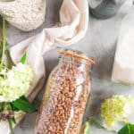 Half gallon glass jar filled with beans laying on its side.
