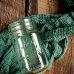 Empty pint mason jar on a teal cloth.