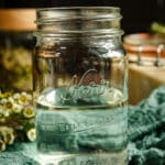 Close up of pint sized glass jar half filled with water.
