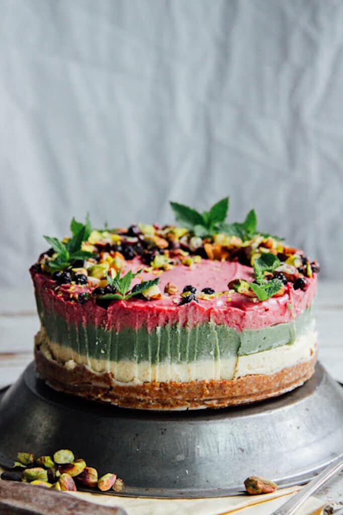 Triple layer cheesecake with cream, green, and pink layers. 