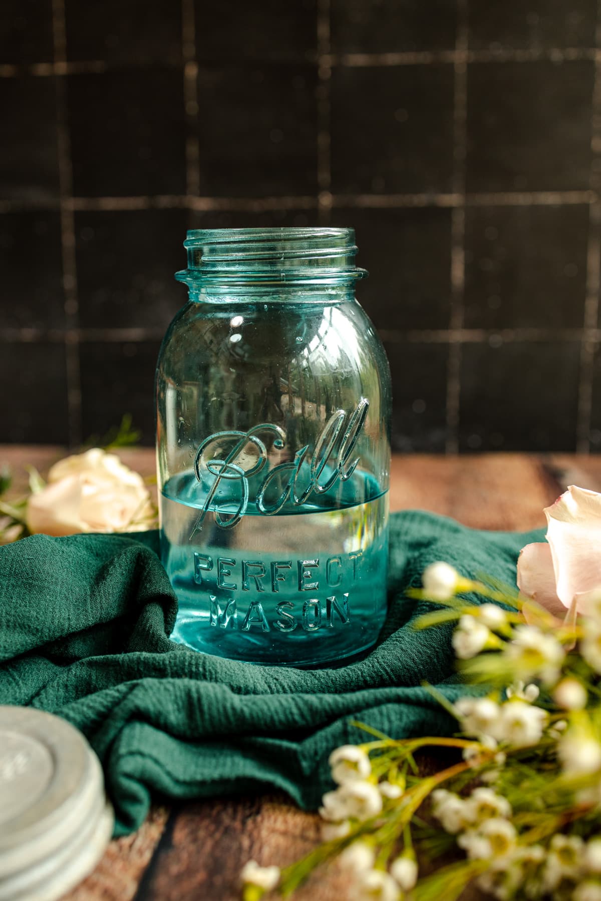 Blue glass quart sized jar filled with water.