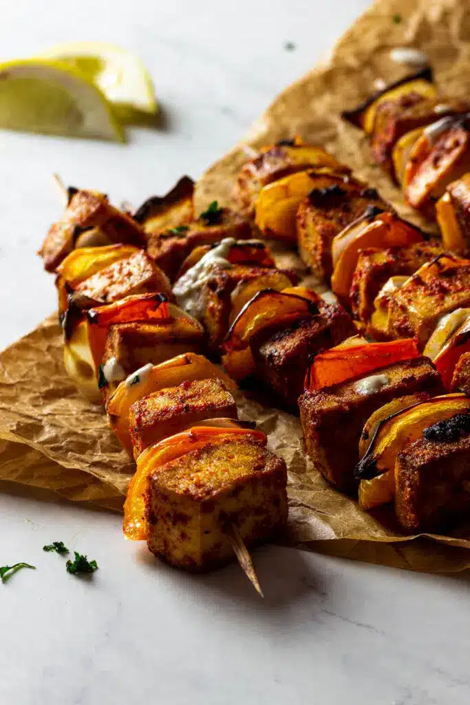 Grilled vegan tofu skewers on a parchment paper.