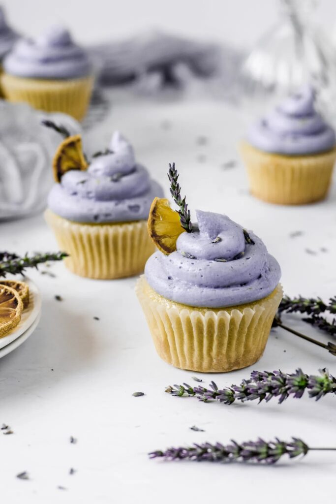 Four lemon lavender cupcakes with purple frosting.