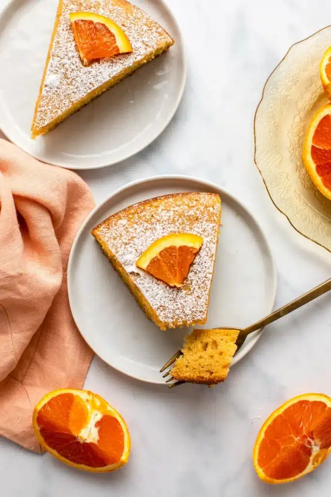 Slices of orange cake with orange slices on top.