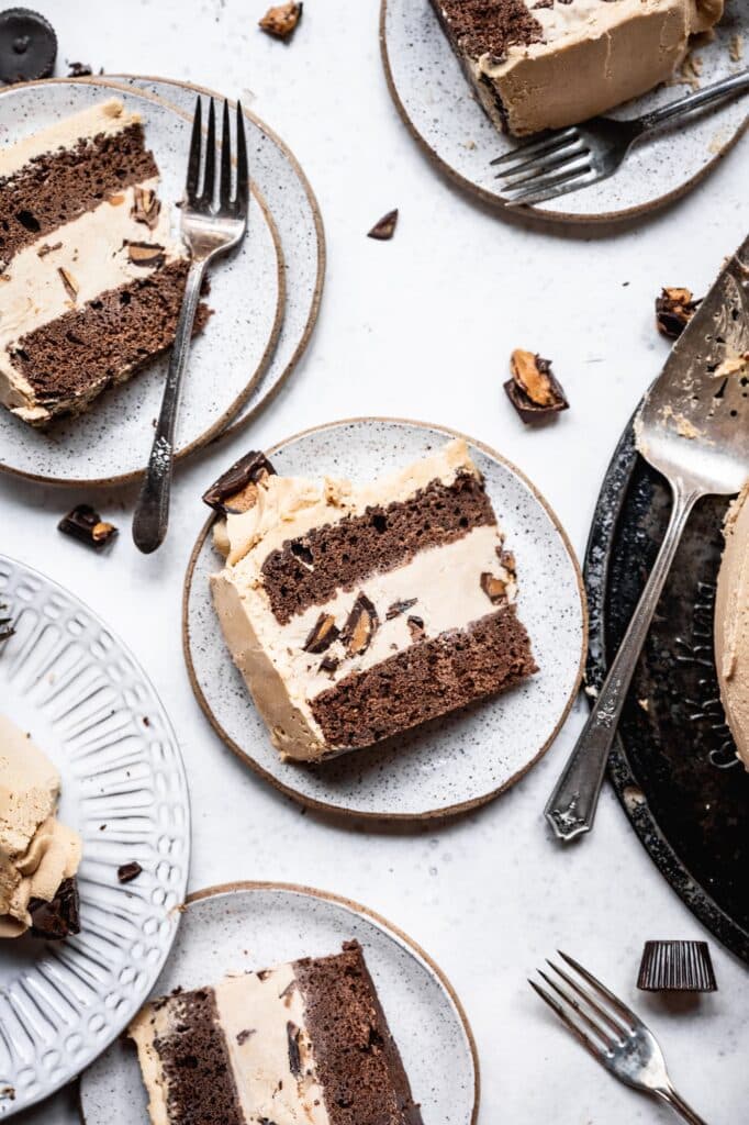 Slices of peanut butter chocolate ice cream cake on white plates.