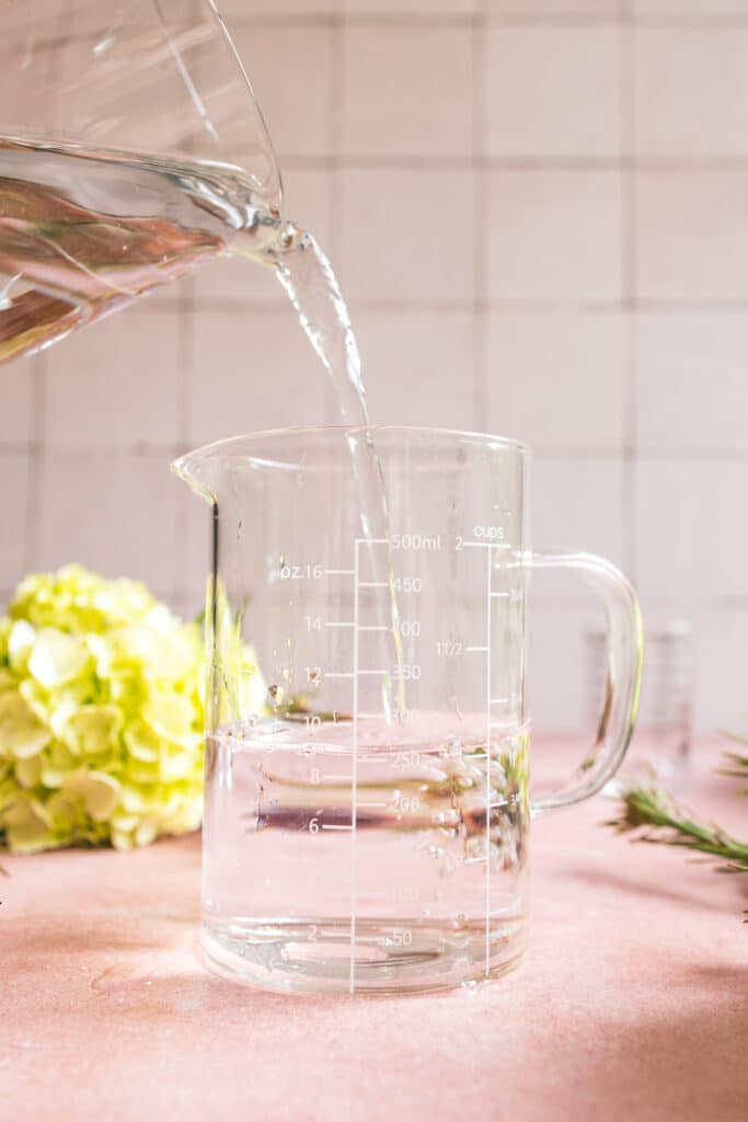 500mL glass measuring cup pouring into another 500mL glass measuring cup.