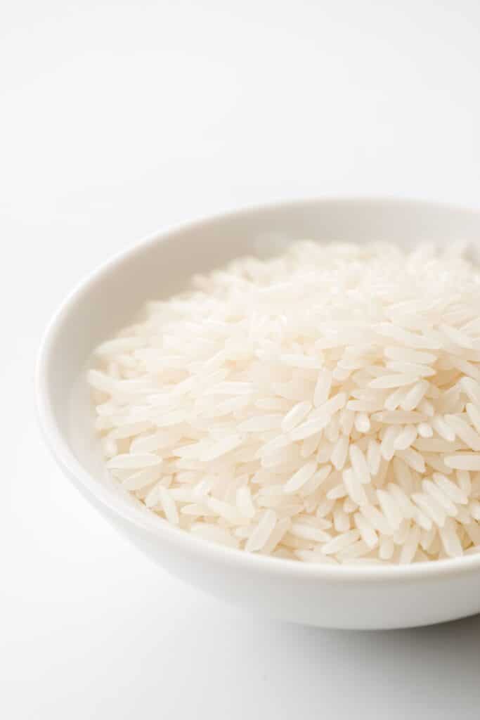 White jasmine rice in a white bowl on a white counter. 