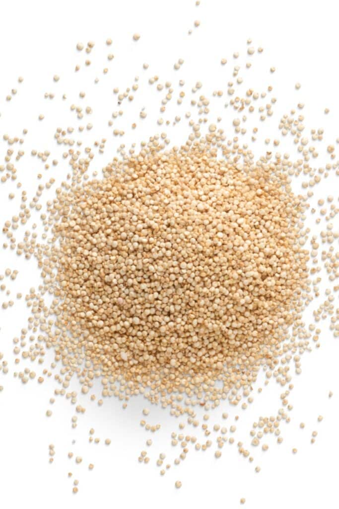 White-cream pile of quinoa on a white surface.