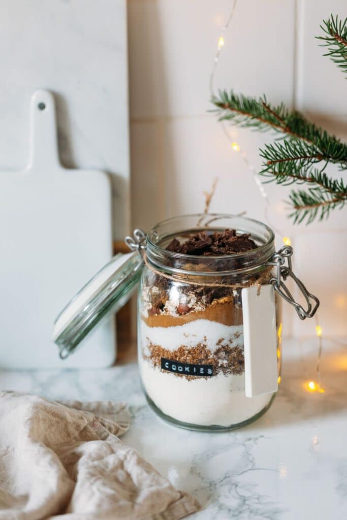Homemade cookie ingredients in a glass jar with label.