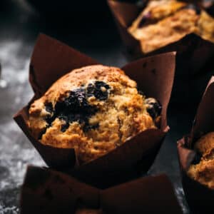 Close up of blueberry muffins in brown tulip wrapper.