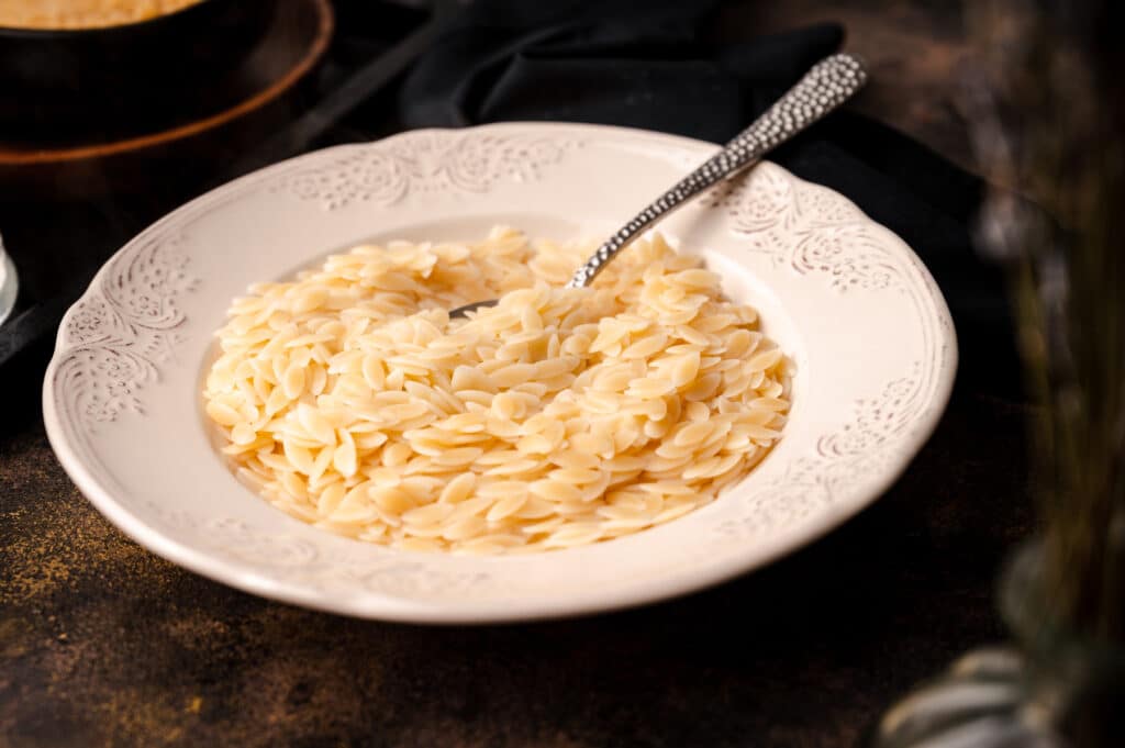 White bowl of cooked orzo.